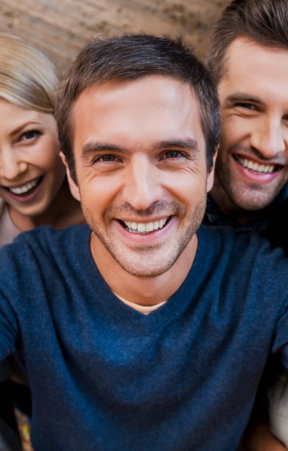 Group of people standing on a porch taking a selfie